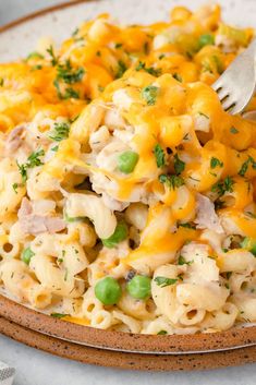 a plate full of macaroni and cheese with a fork stuck in the pasta