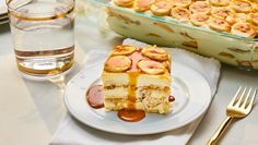 a piece of cake sitting on top of a white plate next to a glass dish