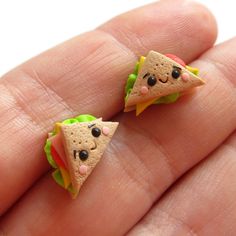 two tiny sandwiches with eyes are on someone's hand