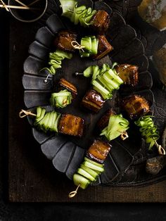 some food is sitting on a plate with chopsticks and other foods around it