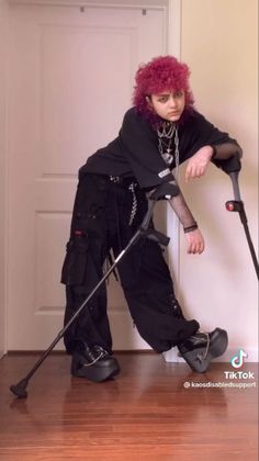 a woman with red hair is leaning against a wall and holding a broom in her hand