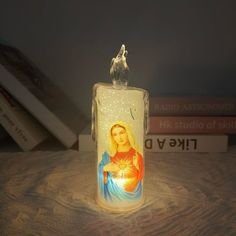 an illuminated candle with the image of mary on it