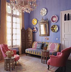 a living room filled with furniture and a chandelier hanging from the ceiling next to a window