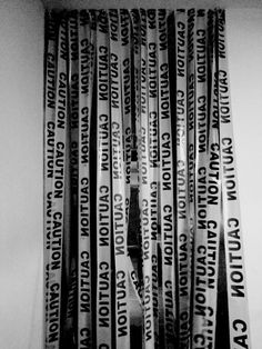 black and white photograph of skis stacked on top of each other in front of a curtain