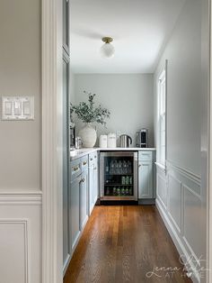 an empty kitchen with wood floors and white cabinets