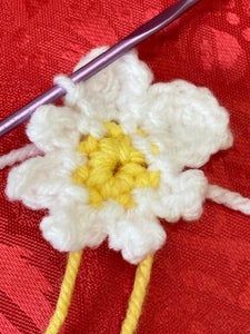 the crochet flower is being worked on