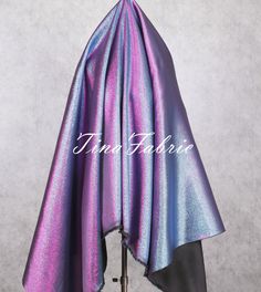 a purple and blue shawl draped over a mannequin