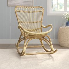 a wicker rocking chair sitting on top of a carpeted floor next to a window