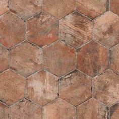 a close up view of a tile floor with hexagonal tiles in brown tones