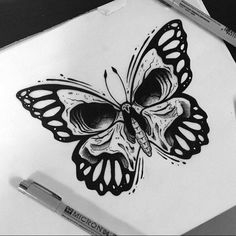 a black and white drawing of a butterfly on a piece of paper next to a marker