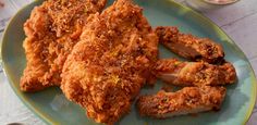 fried chicken on a white plate sitting on a checkered table cloth