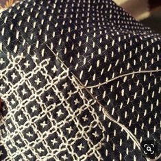 a close up view of a black and white tie with an intricate design on it