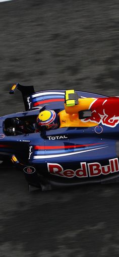 a red bull racing car driving down the track