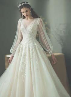 a woman in a white wedding dress standing next to a wall