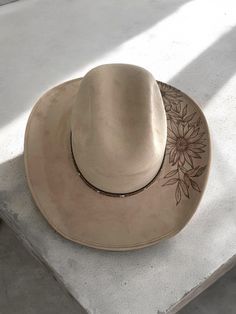 Howdy y'all! Introducing our latest handmade creation: a stunning tan suede cowboy hat in a size medium, featuring a custom sunflower burned pyrography design. 🌻🔥 This unique piece is perfect for adding a touch of boho chic to your outfit or stand out at your next music festival. 🎶 Get ready to turn heads and soak up the sun in style with this one-of-a-kind cowboy hat!  #Handmade #CowboyHat #SunflowerDesign #BohoChic #EtsySeller Cowboy Hut, Pyrography Designs, Apple Jack, Chapeau Cowboy, Painted Hats, Hat Handmade, Sunflower Design, Tan Suede, Cowboy Hat