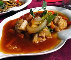 two white plates filled with food on top of a red table cloth covered tablecloth