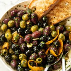 a white bowl filled with olives and bread