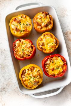 six stuffed peppers in a baking dish on a counter top, ready to be eaten