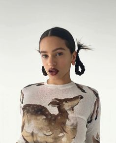 a woman in a white sweater with deer on it's shirt and black hair