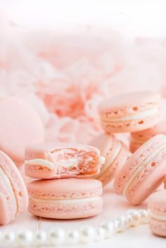 several pink macaroons with white frosting on them