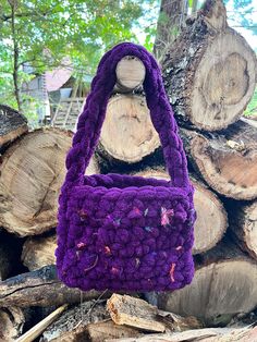 a purple purse sitting on top of a pile of wood