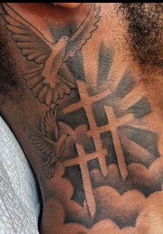 a man with a cross and dove tattoo on his chest