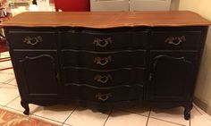 a black dresser with wooden top in a kitchen