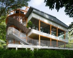 a modern house in the woods with stairs leading up to it's second story