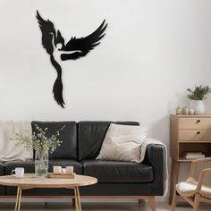 a living room filled with furniture and a black bird wall decal on the wall