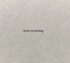 the words trust in time written on white paper