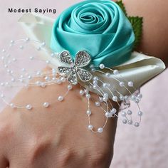 a close up of a person's wrist with a flower and pearls on it