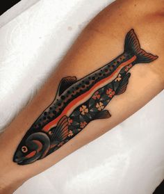 a black and orange fish with flowers on it's leg