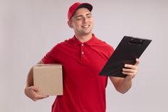 a man in a red shirt is holding a box and a clipboard