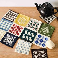 knitted placemats with snowflakes on them and a teapot in the background