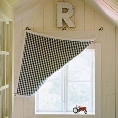 a window with a black and white checkered curtain hanging from it's side