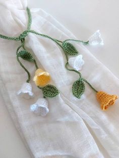 crocheted flowers are attached to white linens