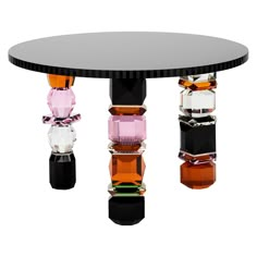 a round table with several different colored glass objects on the top and bottom, all stacked together