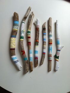 four pieces of driftwood are lined up on a white surface with different patterns and colors