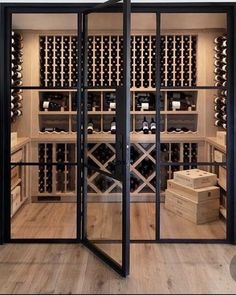 a wine cellar with glass doors open to reveal bottles of wine in the room and wooden boxes on the floor