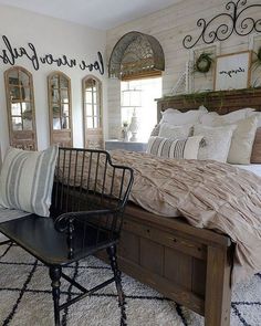 a bedroom with a bed, chair and mirror on the wall next to each other