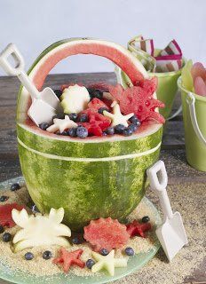 a watermelon bowl filled with fruits and vegetables