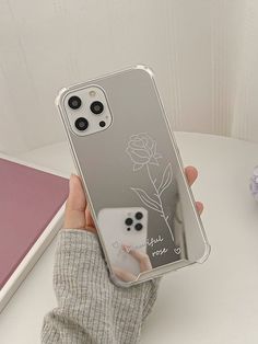 a person holding up a clear case with a flower on the front and back side