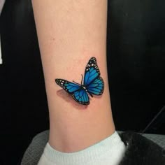 a blue butterfly tattoo on the ankle