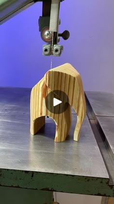 a small wooden elephant on top of a metal table