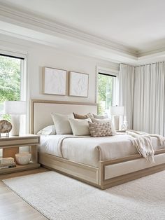 a large bed sitting next to two windows in a bedroom