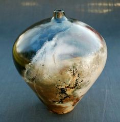 a brown and black vase sitting on top of a table