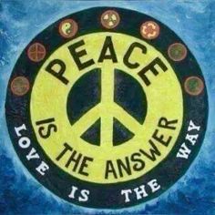 a peace sign painted on the side of a blue and yellow wall with words above it