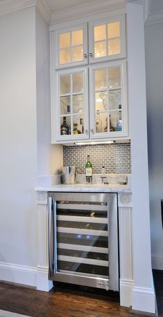 a kitchen with white cabinets and stainless steel appliances on the wall, along with an appliance