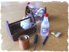 there is a bottle, brush, and other craft items on the wooden table together