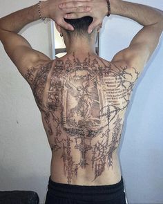 the back of a man with tattoos on his body